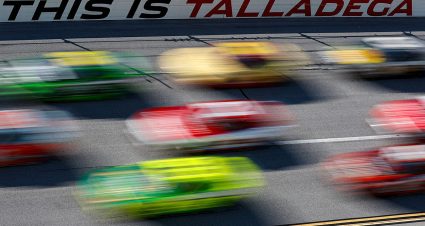 Cars whiz past 'This is Talladega' signage on the outside wall at the Alabama track.