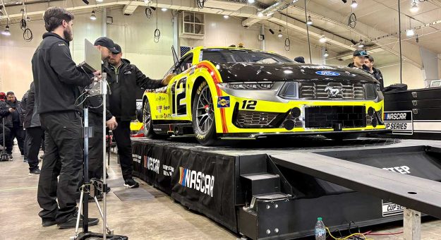 Cup Series cars line up after inspection in the Winston-Salem Fairgrounds events center