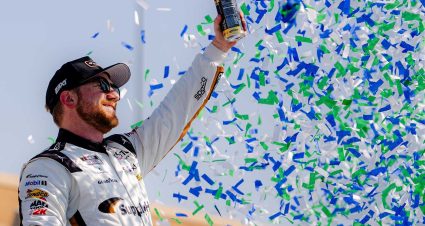 Michael Jordan celebrates with the checkered flag at Kansas Speedway
