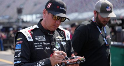 Kyle Busch signs an autograph before a NASCAR Cup Series event.