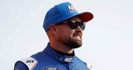 Ricky Stenhouse Jr. waves before a NASCAR Cup Series race in a Hyak Motorsports fire suit.