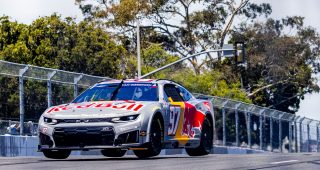 Shane van Gisbergen leaps through the Naval Base Coronado course in. a NASCAR Cup Series car.