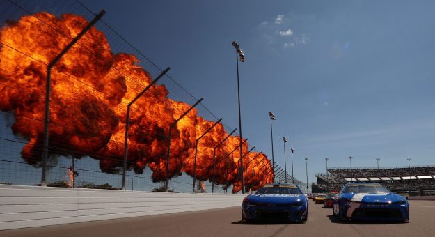 NASCAR Cup Series cars drive past the pyrotechnic display at Gateway.