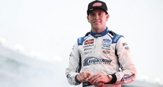 Chandler Smith raises his hand toward the sky at North Wilkesboro Speedway.