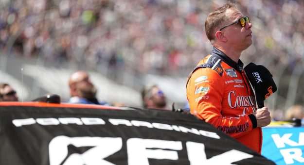 Brad Keselowski looks on next to his RFK Racing Ford in the NASCAR Cup Series.
