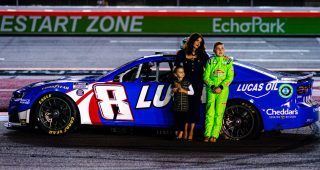 Samantha Busch, Brexton Busch and Lennix Busch stand next to Kyle Busch's car during a celebration of life for Kyle Busch.
